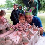 Child and father looking at clay castle